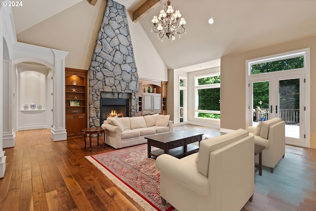 living room with high vaulted ceiling, a fireplace, a notable chandelier, beam ceiling, and wood-type flooring