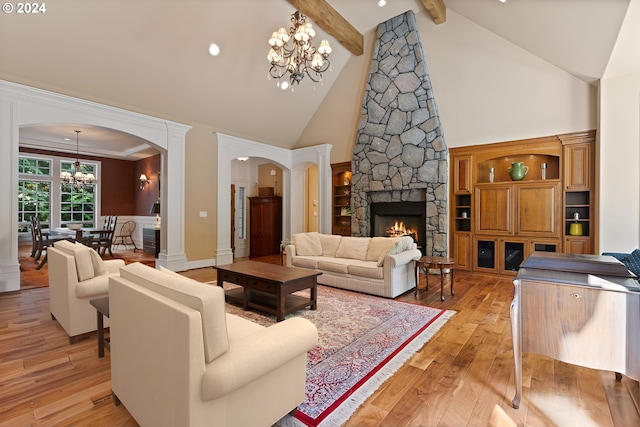 living room with high vaulted ceiling, light hardwood / wood-style flooring, a fireplace, beam ceiling, and a chandelier