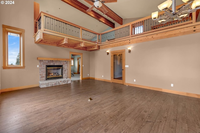 unfurnished living room featuring beam ceiling, wood-type flooring, a fireplace, and high vaulted ceiling