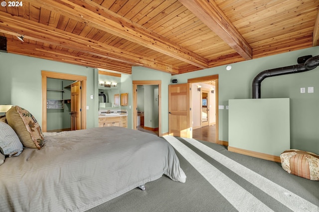 bedroom featuring connected bathroom, a spacious closet, beamed ceiling, and wood ceiling