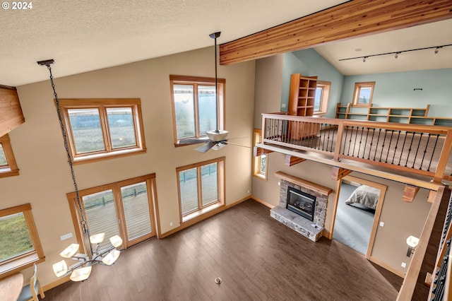 living room with ceiling fan, plenty of natural light, dark hardwood / wood-style floors, and vaulted ceiling