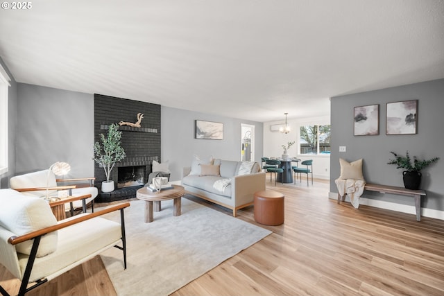 living room with light hardwood / wood-style flooring, a fireplace, and a chandelier