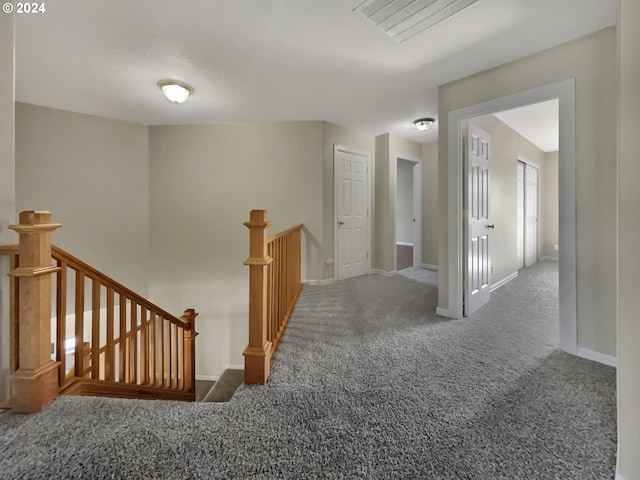 hall featuring dark colored carpet