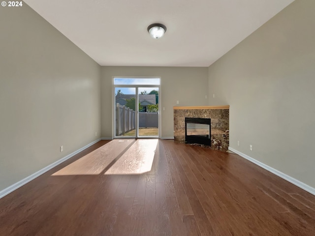 unfurnished living room with a premium fireplace and dark hardwood / wood-style floors