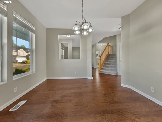 unfurnished dining area featuring dark wood-type flooring and a chandelier