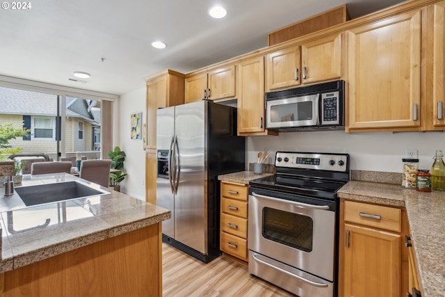 kitchen featuring sink, appliances with stainless steel finishes, and light wood-type flooring