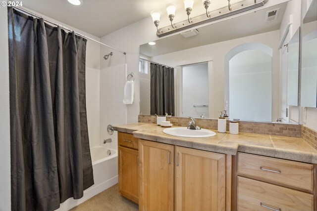 bathroom featuring shower / bath combo and vanity