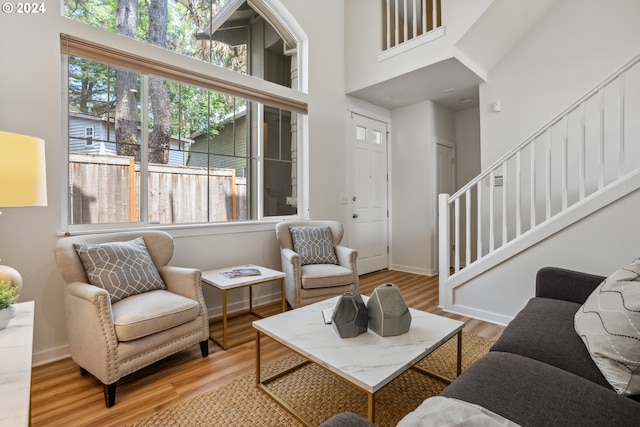 living room featuring light wood-type flooring and a high ceiling