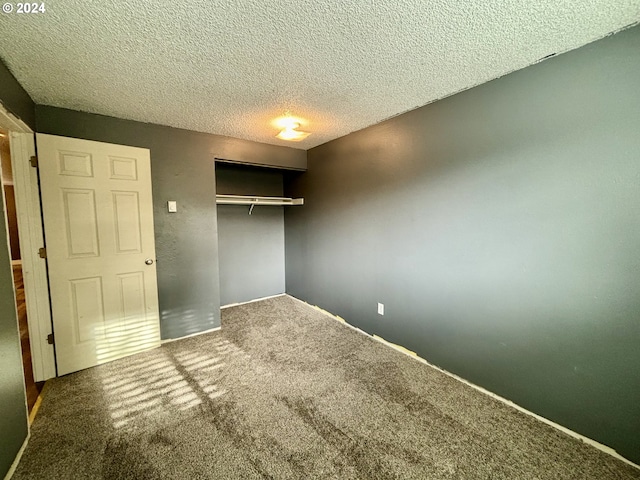 unfurnished bedroom with carpet flooring, a closet, and a textured ceiling