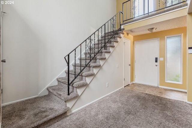 foyer with carpet floors and a high ceiling