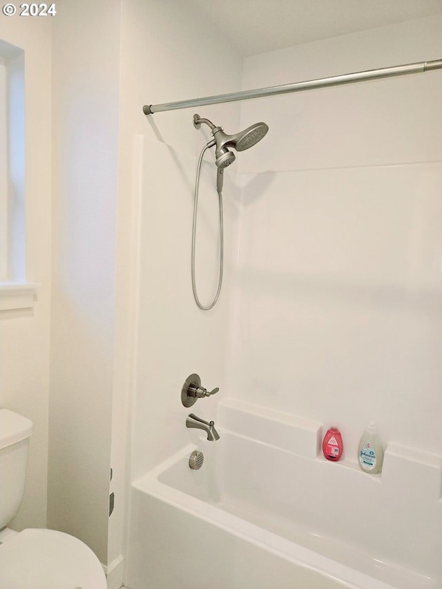 bathroom featuring shower / bathing tub combination and toilet