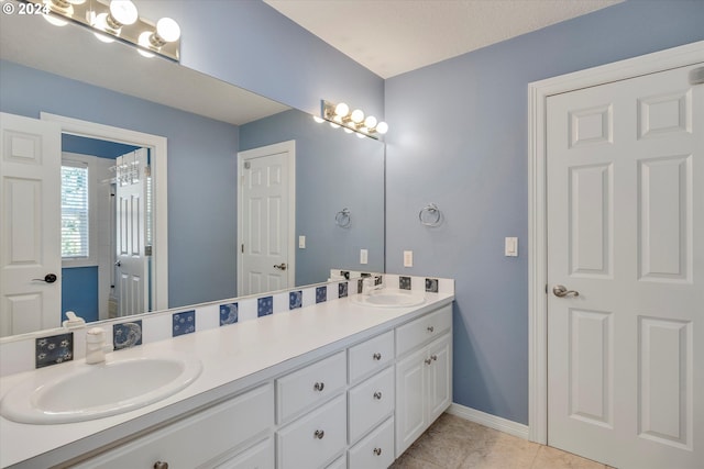 bathroom with tile patterned flooring, vanity, and a textured ceiling