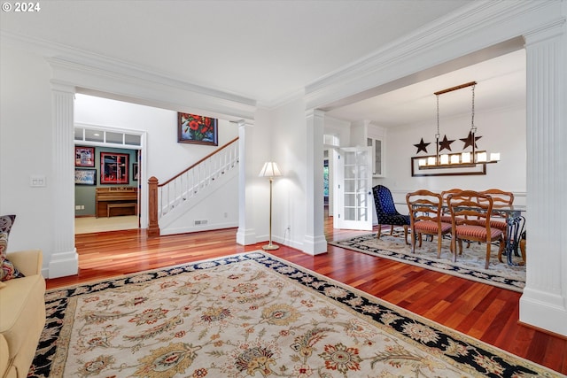 living room with a fireplace, hardwood / wood-style flooring, an inviting chandelier, and crown molding