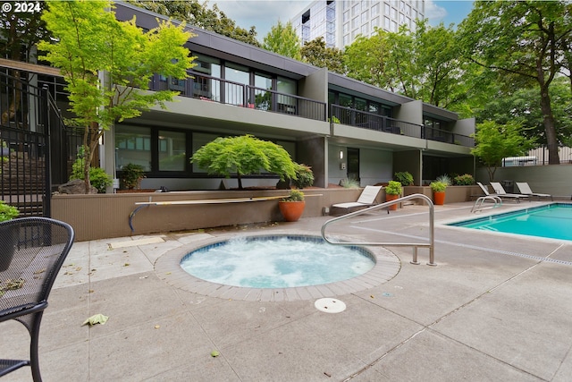 view of swimming pool with a community hot tub and a patio area