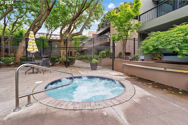 view of pool with a hot tub and a patio area