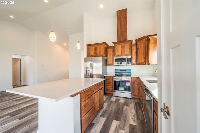 kitchen featuring stainless steel appliances, a center island, pendant lighting, high vaulted ceiling, and dark hardwood / wood-style floors