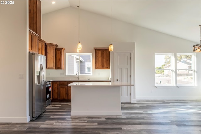 kitchen with a kitchen island, appliances with stainless steel finishes, decorative light fixtures, and dark hardwood / wood-style flooring