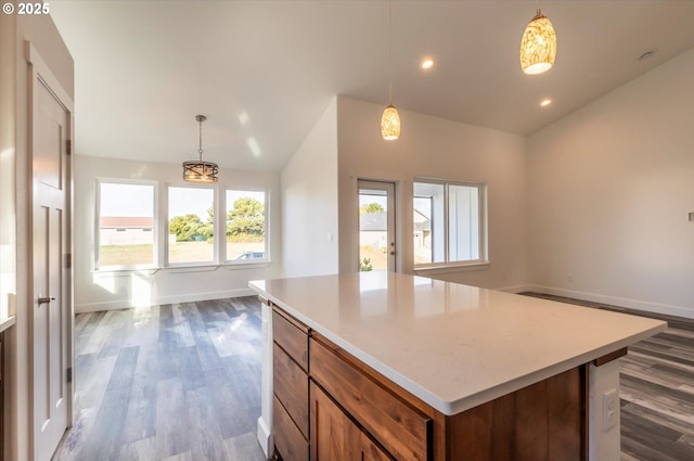 kitchen with a kitchen island, lofted ceiling, wood-type flooring, and hanging light fixtures