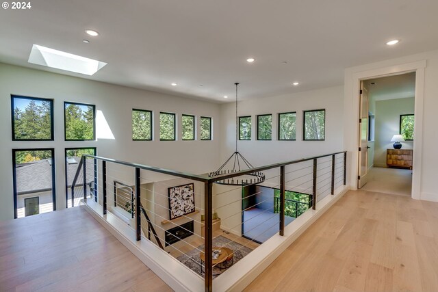 hall featuring hardwood / wood-style floors and a skylight