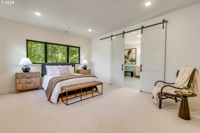 bedroom featuring a barn door and carpet floors