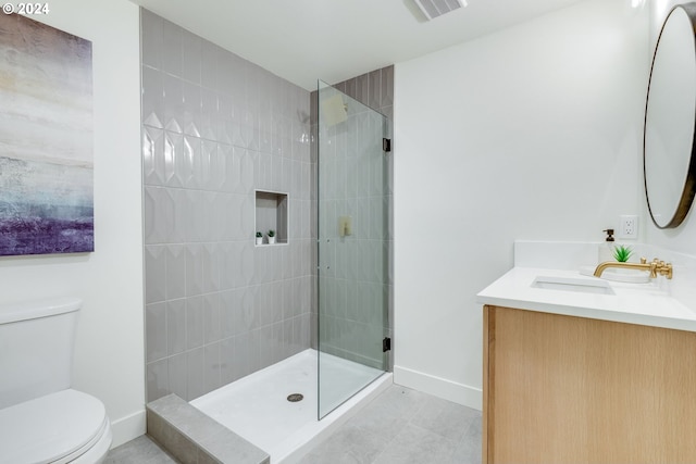 bathroom featuring a tile shower, tile patterned floors, vanity, and toilet