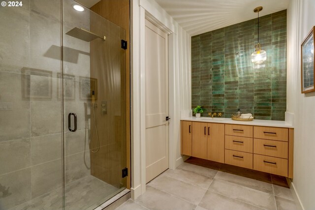 bathroom featuring tile patterned floors, vanity, and a shower with door