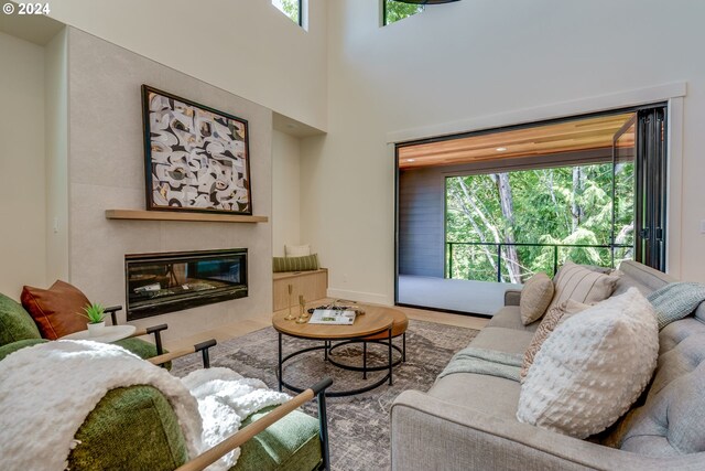 living room with hardwood / wood-style flooring, a healthy amount of sunlight, and a tile fireplace