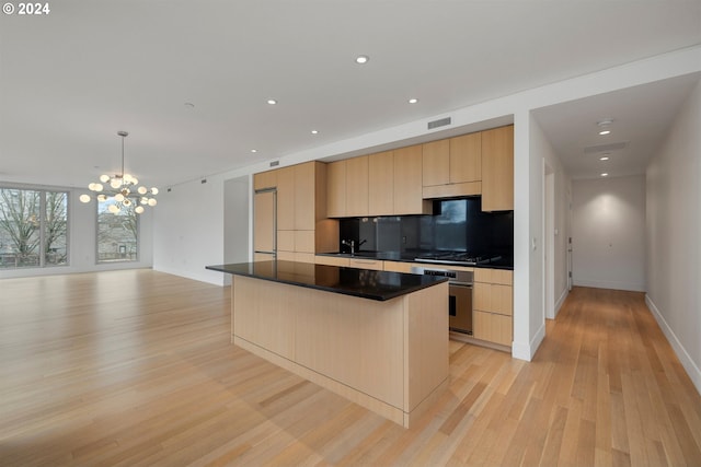 kitchen featuring hanging light fixtures, light hardwood / wood-style flooring, an inviting chandelier, appliances with stainless steel finishes, and light brown cabinetry