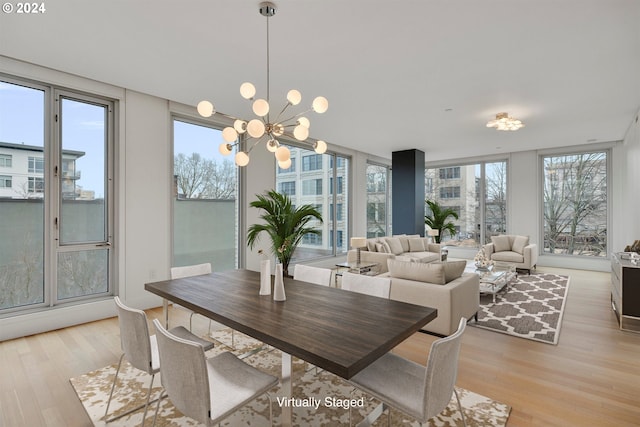 dining space featuring expansive windows, a notable chandelier, light hardwood / wood-style flooring, and a wealth of natural light