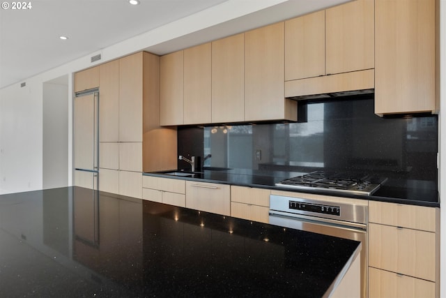 kitchen featuring light brown cabinetry, appliances with stainless steel finishes, sink, and tasteful backsplash