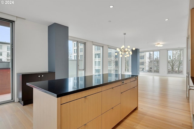 kitchen with light brown cabinetry, a center island, and plenty of natural light