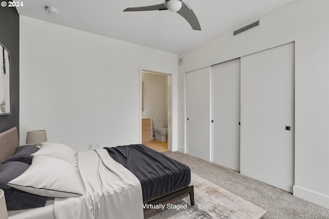 bedroom with ceiling fan, ensuite bath, a closet, and light carpet