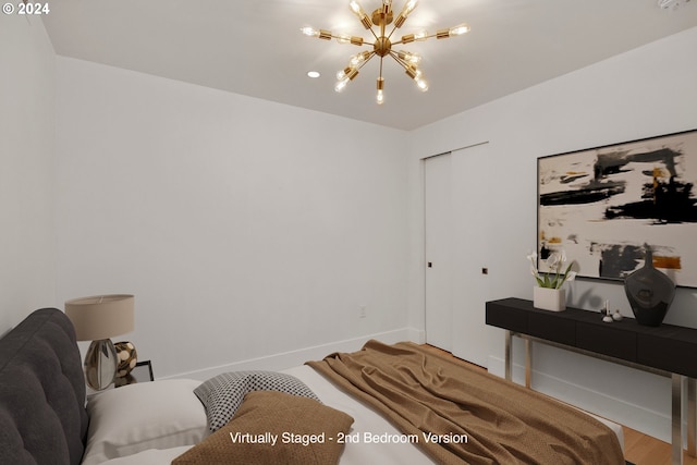 bedroom with wood-type flooring and a notable chandelier