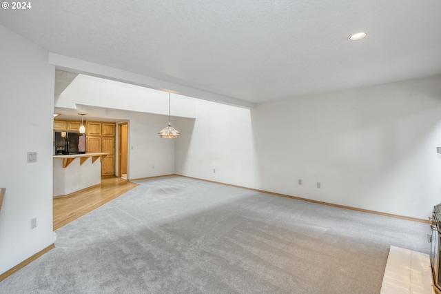 kitchen featuring light brown cabinetry, sink, dishwasher, and light colored carpet