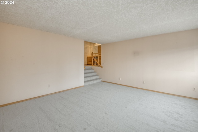 carpeted empty room featuring a textured ceiling