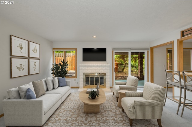 unfurnished living room featuring a chandelier, a brick fireplace, a textured ceiling, and light wood-type flooring