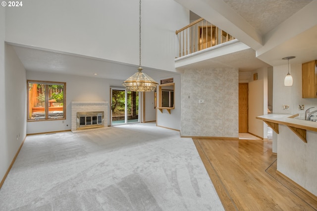 kitchen with tile countertops, light colored carpet, and sink