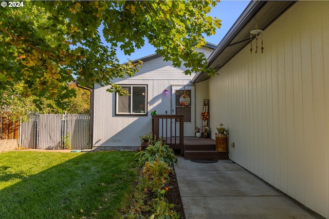 view of exterior entry with a yard