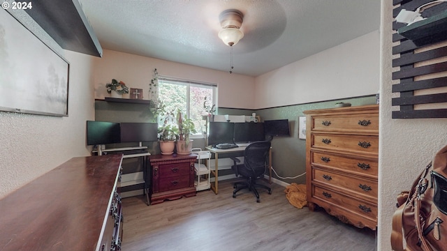 office area with ceiling fan, wood-type flooring, and a textured ceiling