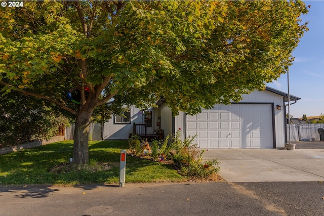 obstructed view of property with a front yard and a garage