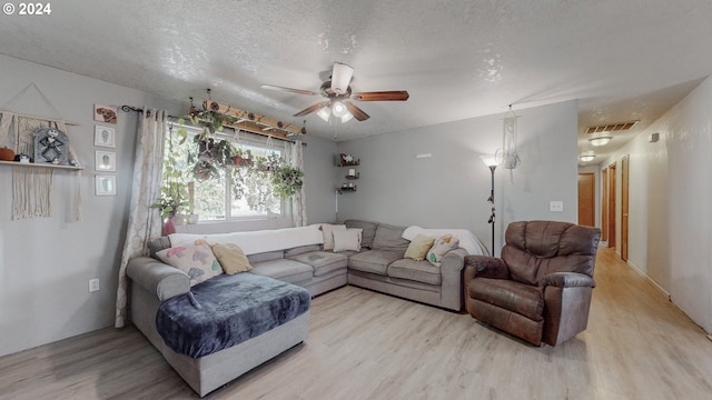 living room with ceiling fan, a textured ceiling, and hardwood / wood-style floors