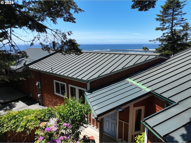 view of property exterior featuring a beach view and a water view