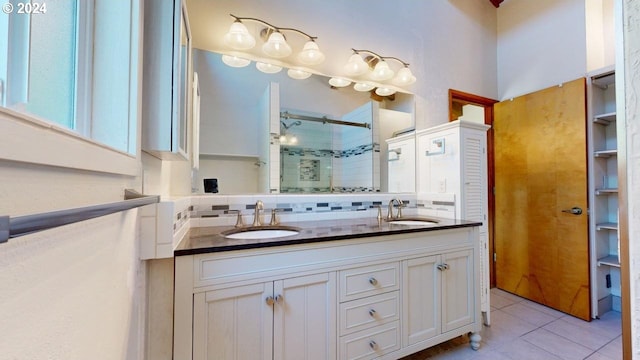 bathroom with tile patterned flooring, vanity, walk in shower, and tasteful backsplash