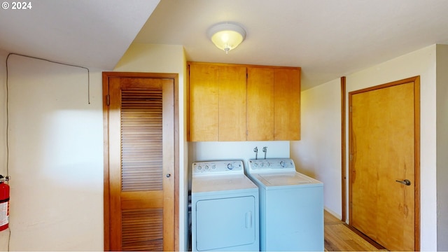 washroom with cabinets, separate washer and dryer, and light hardwood / wood-style flooring