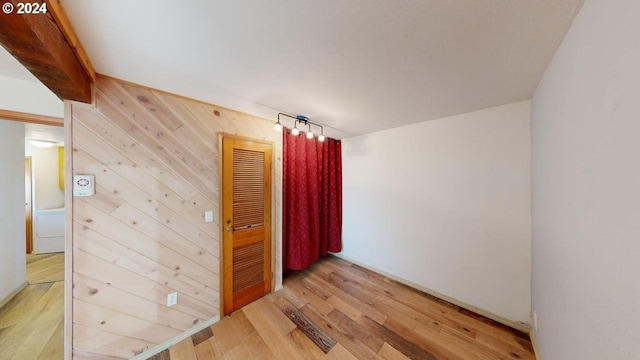 unfurnished room with hardwood / wood-style floors and wooden walls