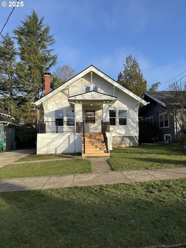 bungalow-style home with covered porch and a front yard