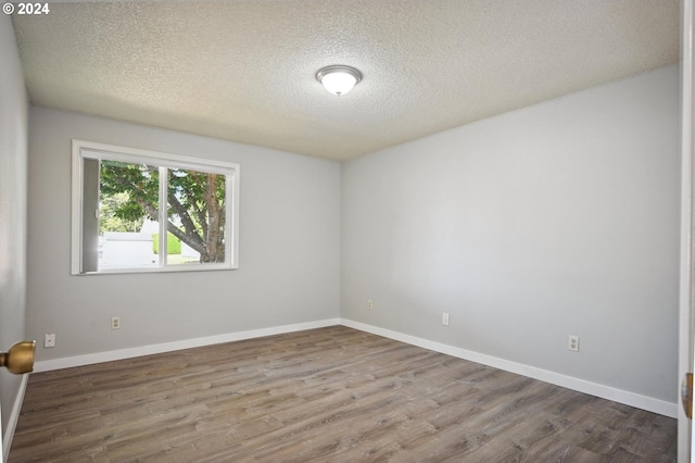 spare room with a textured ceiling and hardwood / wood-style floors