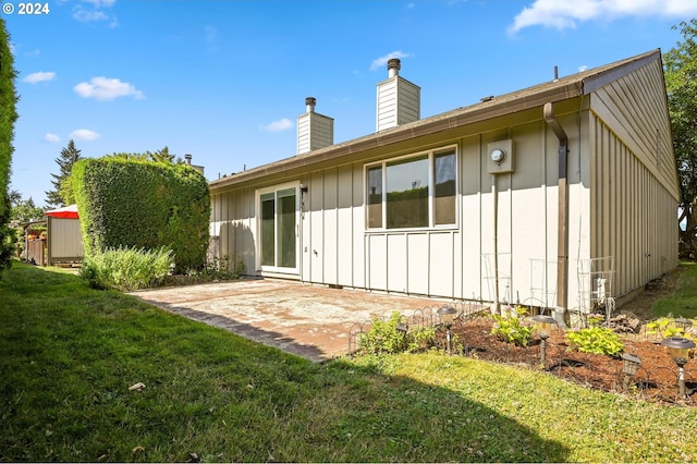 back of house with a yard and a patio area