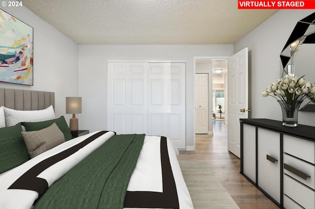 bedroom featuring a textured ceiling, a closet, and light hardwood / wood-style floors