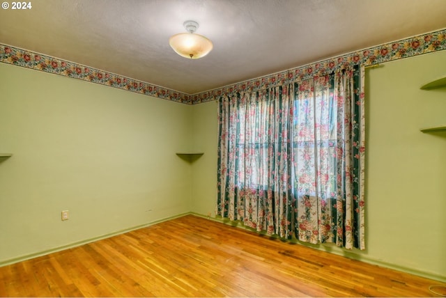 spare room with a textured ceiling and wood-type flooring